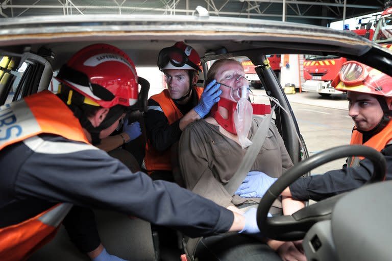 Firefighters keep a person under hypnosis during an extrication exercise in Haguenau, France on May 28, 2013. "These are verbal, gesticular and respiratory techniques that aim to ease pain and anxiety, but that obviously don't replace traditional first aid," explains Cecile Colas-Nguyen, a nurse and member of the fire brigade