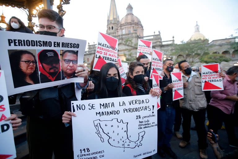 Un grupo de periodistas sostiene carteles que dicen "El asesinato de periodistas no mata la verdad" durante una manifestación contra la violencia contra los periodistas, especialmente por los asesinatos de los periodistas Margarito Martínez y Lourdes Maldonado en Tijuana la semana pasada, en Guadalajara, México, el 25 de enero de 2022.