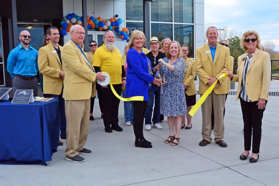 Former Boone County Family Resources Executive Director Robyn Kaufman and current Executive Director Laura Cravens take part in a ribbon-cutting Thursday of the social service agency's new offices on West Ash Street surrounded by Columbia Chamber of Commerce ambassadors.