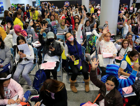 Overseas Filipino Workers (OFW) from Kuwait gather upon arrival at the Ninoy Aquino International Airport in Pasay city, Metro Manila, Philippines February 21, 2018. Following President Rodrigo Duterte's call to evacuate workers after a Filipina was found dead stuffed inside a freezer. REUTERS/Romeo Ranoco