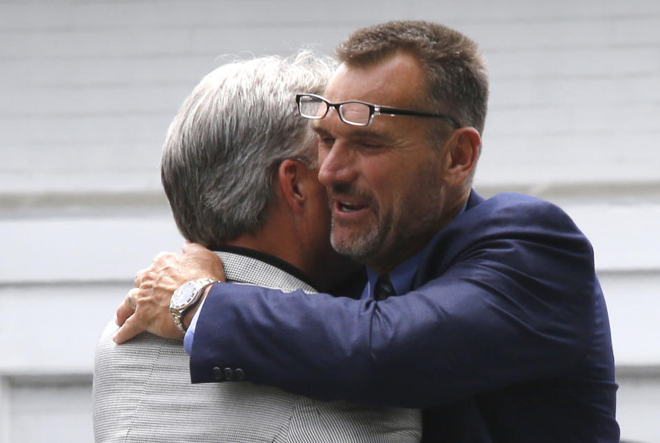 FILE- In this June 16, 2014, file photo, former Pittsburgh Steelers offensive lineman Tunch Ilkin, right, hugs Mike O'Donnell, the brother of former Steelers quarterback Neil O'Donnell, as they arrive for a viewing for former Pittsburgh Steelers head football coach Chuck Noll in Pittsburgh. Ilkin, a Turkis-born two-time Pro Bowl offensive lineman with the Pittsburgh Steelers in the 1980s who went on to become a beloved member of the organization's broadcast team, died on Saturday morning, Sept. 4, 2021, the team said. He was 63. Ilkin, who revealed last fall he was fighting amyotrophic lateral sclerosis (also known as Lou Gehrig's Disease), had been hospitalized recently with pneumonia. (AP Photo/Keith Srakocic, File)