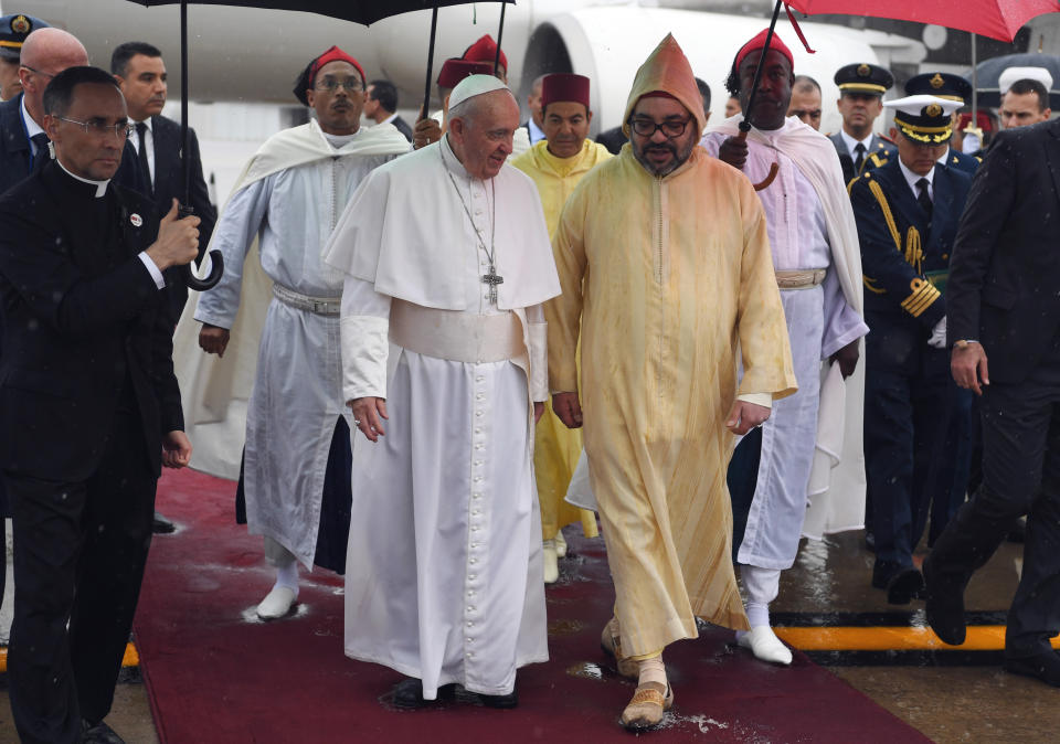 Pope Francis, centre left, is greeted by Morocco's King Mohammed VI, after disembarking from his plane at Rabat-Sale International Airport near the capital Rabat, Saturday, March 30, 2019. Pope Francis has arrived in Morocco for a trip aimed at highlighting the North African nation's tradition of Christian-Muslim ties, while also letting him show solidarity with migrants at Europe's door and tend to a tiny Catholic flock. (Fadel Senna/Pool Photo via AP)