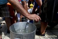 Residents gather water from a fire hydrant at a neighborhood in Santiago, Chile, Monday, Feb. 27, 2017. Millions are without potable water in Santiago's metropolitan area after floods and mudslides cut supplies. (AP Photo/ Esteban Felix)