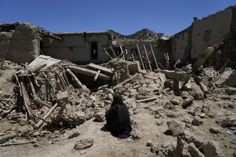 Afghan woman sits amid destruction after an earthquake in Gayan village, in Paktika province, Afghanistan, Friday June 24, 2022. A powerful earthquake struck a rugged, mountainous region of eastern Afghanistan early Wednesday, flattening stone and mud-brick homes in the country's deadliest quake in two decades, the state-run news agency reported. (AP Photo/Ebrahim Nooroozi)