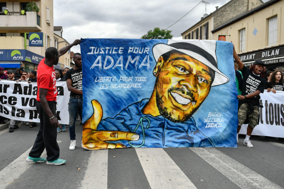 People raise their fists as they take part in a march in memory of Adama Traore, who died during his arrest by the police in July 2016, on July 22, 2017 in Beaumont-sur-Oise, northeast of Paris. | Julien Mattia—Getty