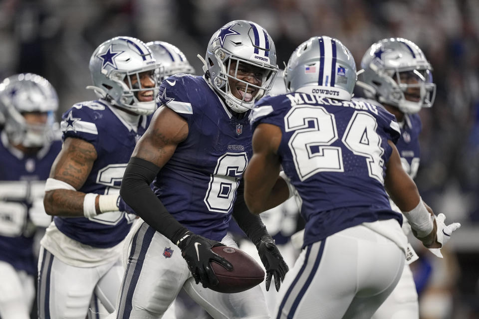 Dallas Cowboys safety Donovan Wilson (6) holds the ball while reacting with safety Israel Mukuamu (24) after intercepting a pass by Detroit Lions quarterback Jared Goff during the second half of an NFL football game, Saturday, Dec. 30, 2023, in Arlington, Texas. (AP Photo/Sam Hodde)