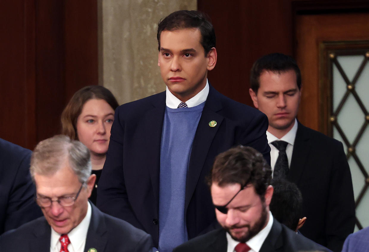 Rep.-elect George Santos, wearing a subdued expression, arrives with other lawmakers at the 118th Congress.