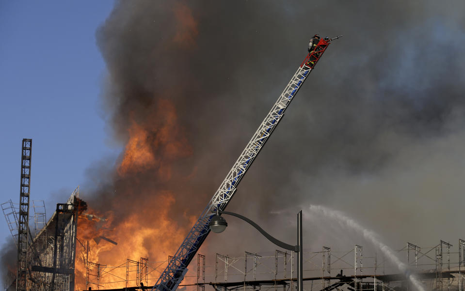 A firefighter prepares to spray water on a fire in San Francisco, Tuesday, March 11, 2014. The major fire burning in San Francisco's Mission Bay neighborhood sent an enormous plume of black smoke high into the sky. There were no initial reports of injuries. The four-alarm fire that began about 5 p.m. was ravaging a high-rise building under construction and moving down a block. Fire-suppression systems had not yet been installed in the building, making the battle against the blaze more difficult, Fire Department spokeswoman Mindy Talmadge said. (AP Photo/Jeff Chiu)