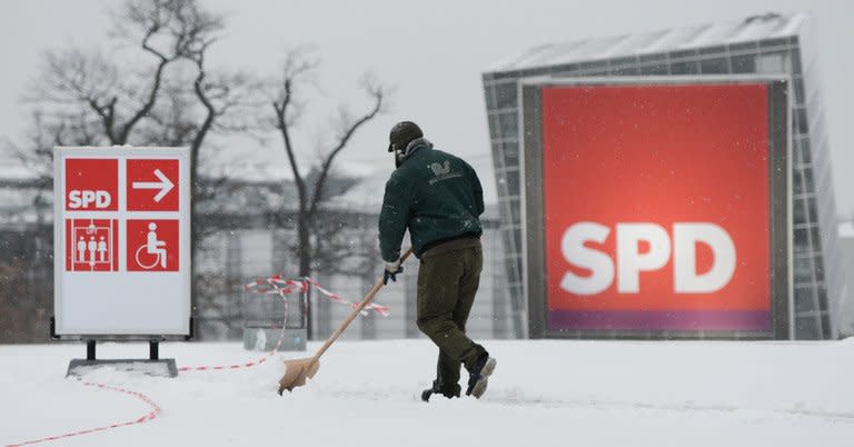 File picture shows a man sweeping snow from a street before a special federal party conference of Germany's Social Democratic Party (SPD) last year in Hanover. The opposition SPD mark its 150th birthday Thursday, with French President Francois Hollande as the only foreign speaker and conservative Chancellor Angela Merkel in the audience