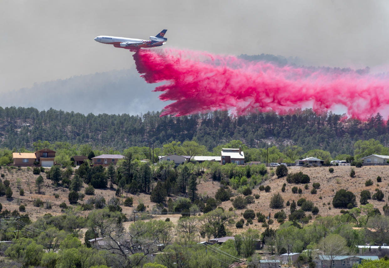 An aircraft dumps fire retardant near the Hermit Peak Fire in New Mexico.