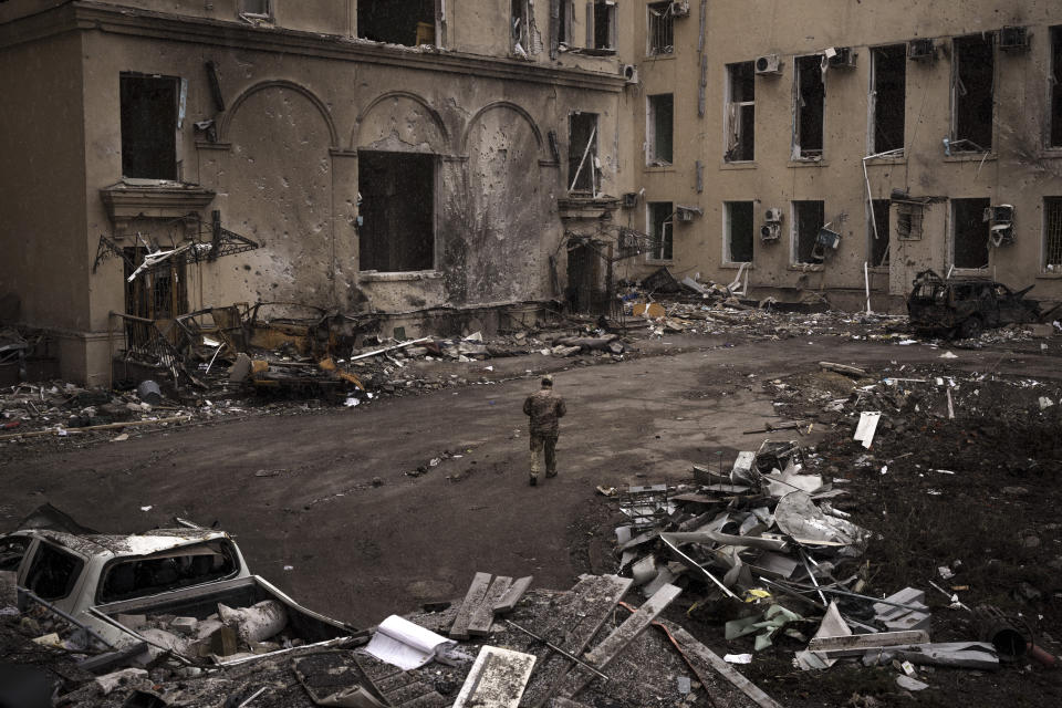 A Ukrainian serviceman walks outside the regional administration building that was heavily damaged after a Russian attack earlier this month in Kharkiv, Ukraine, Sunday, March 27, 2022. (AP Photo/Felipe Dana)