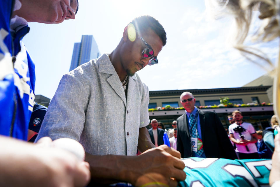 Seattle Mariners' Julio Rodriguez signs an autograph during the baseball All-Star Game red carpet show Tuesday, July 11, 2023, in Seattle. (AP Photo/Lindsey Wasson)