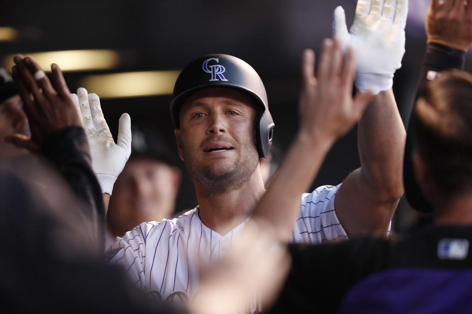 Colorado Rockies' Matt Holliday is congratulated as he returns to the dugout after hitting a solo home run off Los Angeles Dodgers starting pitcher Clayton Kershaw in the second inning of a baseball game Friday, Sept. 7, 2018, in Denver. (AP Photo/David Zalubowski)