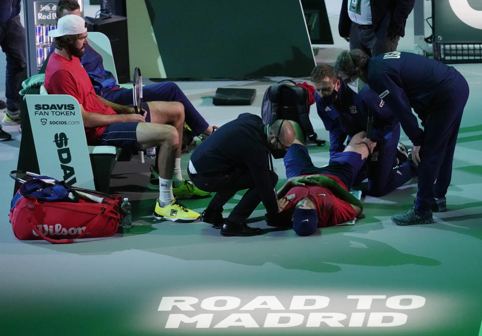 United States' Jack Sock receives a medical treatment during the Davis Cup men's doubles Finals tennis match against Colombia's Juan Sebastian Cabal and Robert Farah, at the Pala Alpitour in Turin, Italy, Sunday, Nov. 28, 2021. (AP Photo/Antonio Calanni)