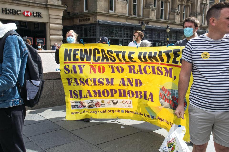 Protestors carrying a banner that says NEWCASTLE UNITE SAY NO TO RACISM FASCISM AND ISLAMOPHOBIA