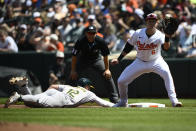 Oakland Athletics' Max Schuemann (12) dives back safely against Baltimore Orioles first baseman Ryan Mountcastle (6) on a pickoff-attempt during the second inning of a baseball game, Sunday, April 28, 2024, in Baltimore. (AP Photo/Nick Wass)