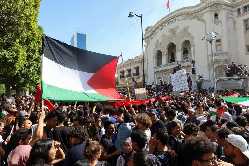 Varias personas sostienen banderas durante una protesta propalestina tras la muerte de cientos de palestinos en una explosión en el hospital Al-Ahli de Gaza, de la que se culparon mutuamente las autoridades israelíes y palestinas, en Túnez