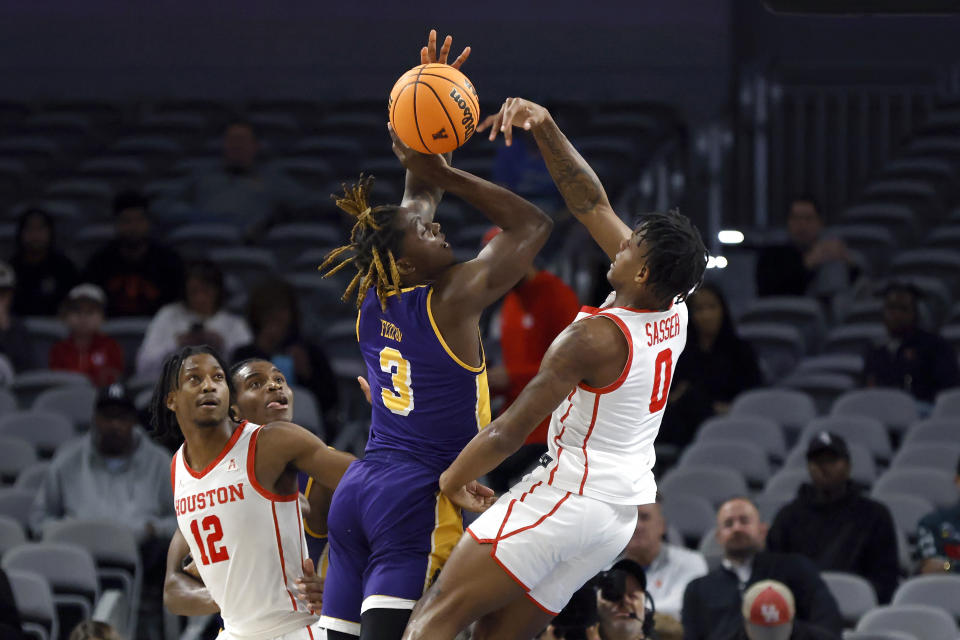 Houston guard Marcus Sasser (0) blocks a shot by East Carolina guard RJ Felton (3) during the first half of an NCAA college basketball game in the quarterfinals of the American Athletic Conference Tournament, Friday, March 10, 2023, in Fort Worth, Texas. (AP Photo/Ron Jenkins)