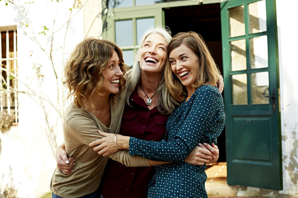 Three friends hugging and smiling