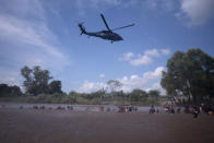 <p>A Mexican Federal Police helicopter flies close to the Suchiate River that connects Mexico and Guatemala, to create a downwash to discourage a new group of Central American migrants bound for the U.S border who are wading across the river, in Tecun Uman, Guatemala, Monday, Oct. 29, 2018. The first group was able to cross the river on rafts, an option now blocked by Mexican Navy river and shore patrols. (Photo: Santiago Billy/AP) </p>