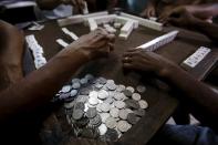 Residents play mahjong in Malabon, Metro Manila, Philippines March 21, 2015. When paying your final respects for a relative or friend, the last thing you might expect to see at the wake is people placing bets on a card game or bingo. Not in the Philippines. Filipinos, like many Asians, love their gambling. But making wagers on games such as "sakla", the local version of Spanish tarot cards, is particularly common at wakes because the family of the deceased gets a share of the winnings to help cover funeral expenses. Authorities have sought to regulate betting but illegal games persist, with men and women, rich and poor, betting on anything from cockfighting to the Basque hard-rubber ball game of jai-alai, basketball to spider races. Many told Reuters photographer Erik De Castro that gambling is only an entertaining diversion in a country where two-fifths of the population live on $2 a day. But he found that some gamble every day. Casino security personnel told of customers begging to be banned from the premises, while a financier who lends gamblers money at high interest described the dozens of vehicles and wads of land titles given as collateral by those hoping lady luck would bring them riches. REUTERS/Erik De Castro PICTURE 21 OF 29 FOR WIDER IMAGE STORY "HIGH STAKES IN MANILA". SEARCH "BINGO ERIK" FOR ALL IMAGES.