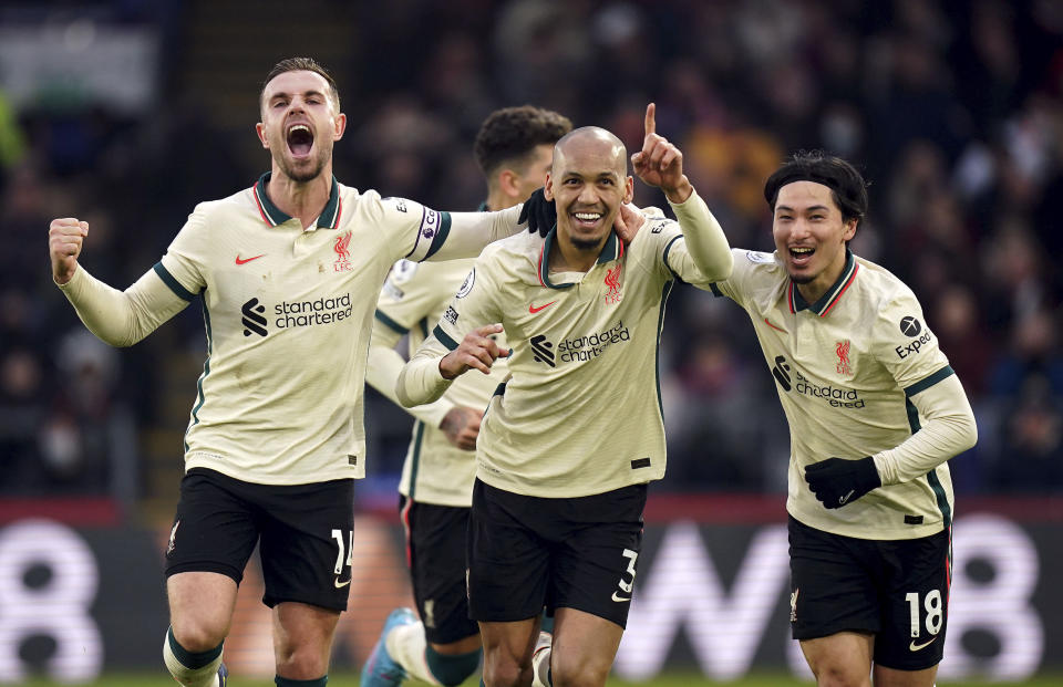 Liverpool's Fabinho celebrates scoring his side's third goal of the game with team-mates Jordan Henderson, left, and Takumi Minamino during the English Premier League soccer match between Crystal Palace and Liverpool at Selhurst Park, London, Sunday, Jan. 23, 2022. (Adam Davy/PA via AP)