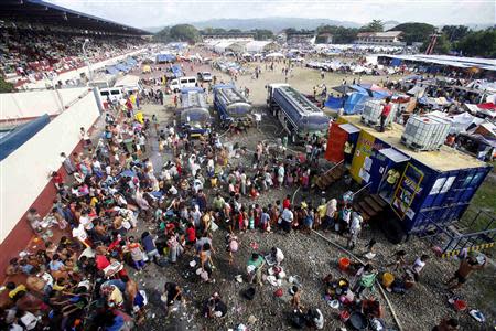 Residents queue for a shower in a stadium turned into an evacuation centre in Zamboanga city in southern Philippines September 18, 2013. REUTERS/Erik De Castro