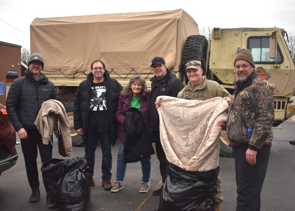 Adrian residents Jacob Anderson, second from left and Teri Anderson, third from left, were among those individuals who donated items including blankets, pillows and other bedding material to Lenawee County's homeless shelter, Share the Warmth of Lenawee, during the shelter's three-day fundraising campaign, 