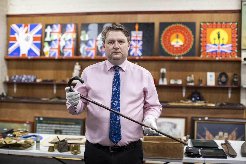 <p>Auctioneer Carl Bennett holding a walking stick once belonging to Michael Collins, one of the lots for sale at Bloomfield Auctions in east Belfast next week. Picture date: Monday September 20, 2021.</p>
