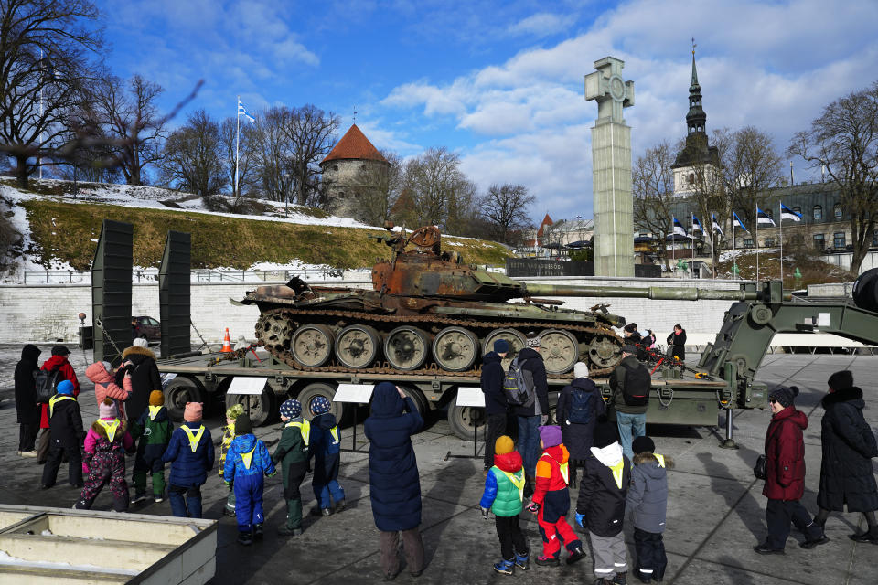 People look at a destroyed Russian T-72B3 tank installed as a symbol of the Russia Ukraine war to mark the first anniversary of Russia's full-scale invasion of Ukraine, in Freedom Square in Tallinn, Estonia, Wednesday, March 1, 2023. (AP Photo/Pavel Golovkin)