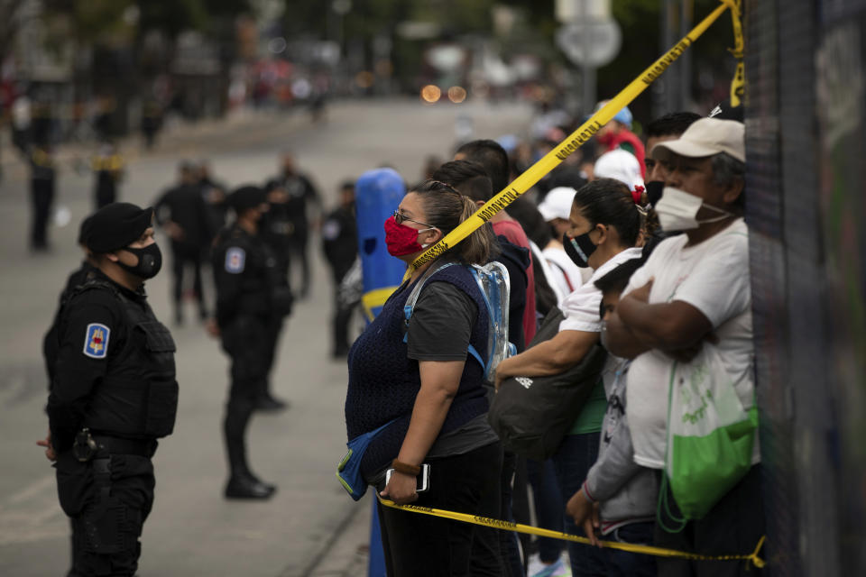 Spectators take position near the perimeter to where the annual Independence Day military parade will pass on Mexico City’s Juarez Avenue, Wednesday, Sept. 16, 2020. Mexico celebrates the anniversary of its independence uprising of 1810. (AP Photo/Fernando Llano)