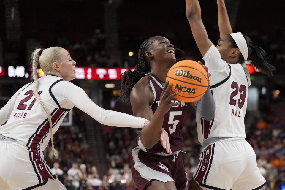 Texas A&M guard Aicha Coulibaly drives to the basket between South Carolina forward Chloe Kitts guard Bree Hall during the first half of an NCAA college basketball game at the Southeastern Conference women's tournament Friday, March 8, 2024, in Greenville, S.C. (AP Photo/Chris Carlson)