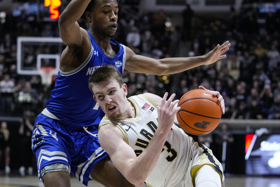 Purdue guard Fletcher Loyer (2) falls as he drives around New Orleans guard Jordan Johnson (1) during the second half of an NCAA college basketball game in West Lafayette, Ind., Wednesday, Dec. 21, 2022. (AP Photo/Michael Conroy)