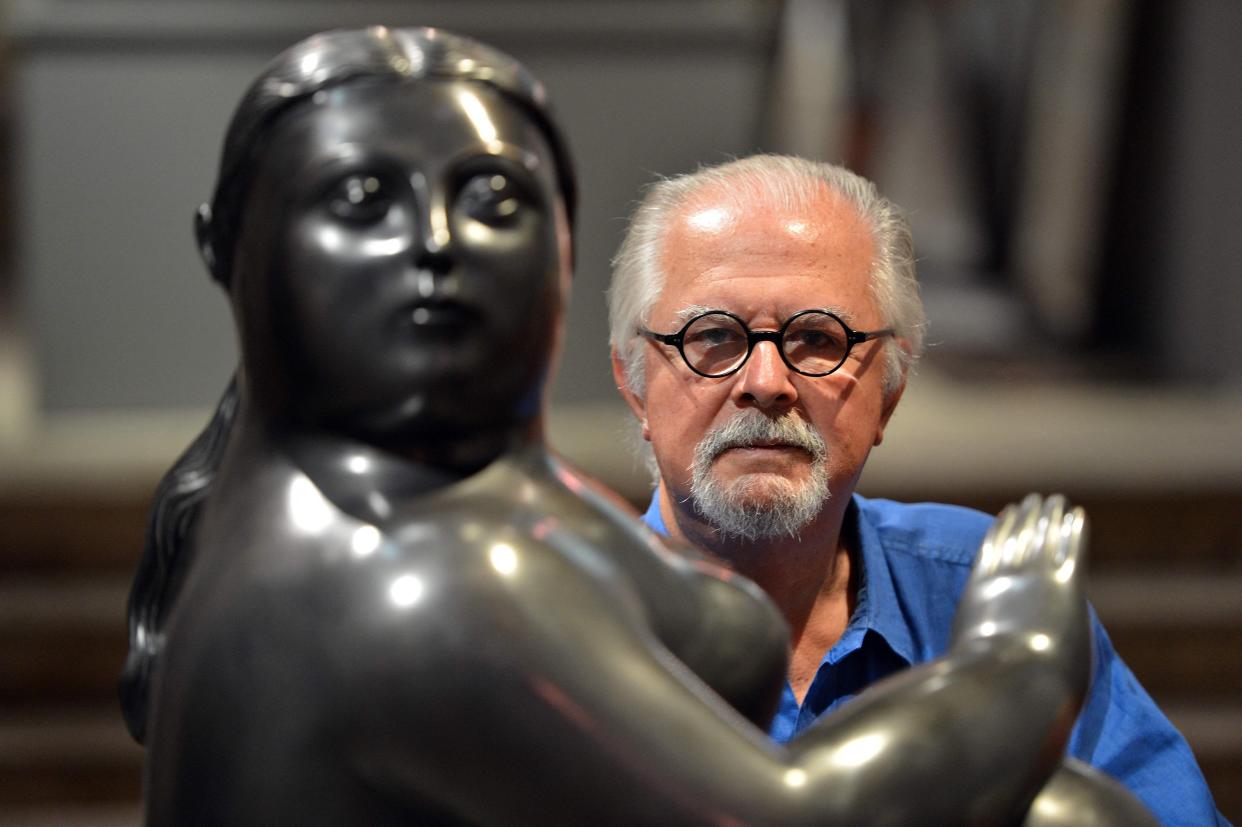 Colombian artist Fernando Botero poses on July 6, 2012 next to one of his sculptures in Santo Augustino's Church in Pietrasanta, Tuscany, prior to the opening of an exhibition.