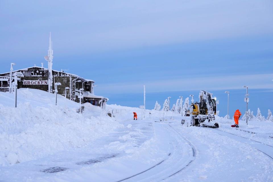 Railroad workers clear the tracks of snow on northern Germany's highest mountain Brocken (AP)