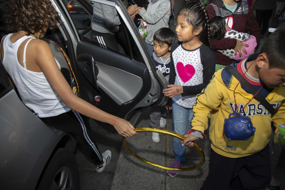 Paulina Miramar gifts a hula hoop to a youth on Three Kings Day at the base of the Angel of Independence monument in Mexico City, Sunday, Jan. 6, 2019. As Christians around the world celebrate the epiphany on Sunday, which recalls the three kings, or magi, who reportedly followed a star to find the baby Jesus, children throughout Latin America traditionally unwrap holiday gifts that in other parts of the world are delivered by Santa on Christmas Day. (AP Photo/Anthony Vazquez)