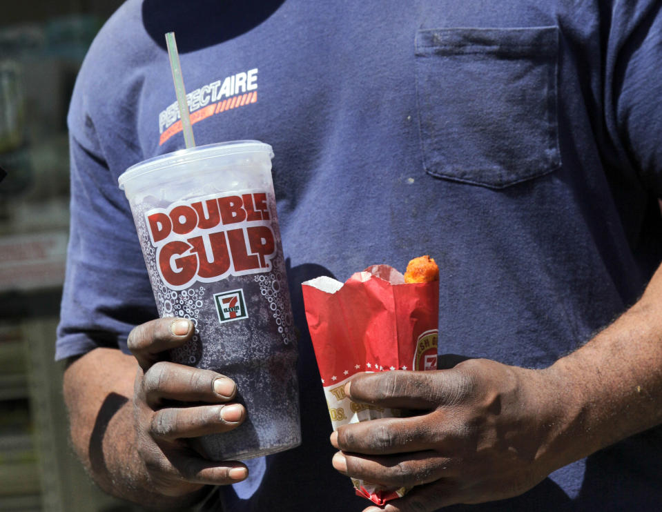 FILE - In this May 31, 2012 file photo, a man leaves a 7-Eleven store with a Double Gulp drink, in New York. If New York City bans big sodas, what's next? Large slices of pizza? Double-scoop ice cream cones? Tubs of movie-theater popcorn? The 16-ounce strip steak? Opponents of the proposed ban may use that slippery-slope argument along with other legal strategies to try to block the first-in-the-nation rule. (AP Photo/Richard Drew, File)