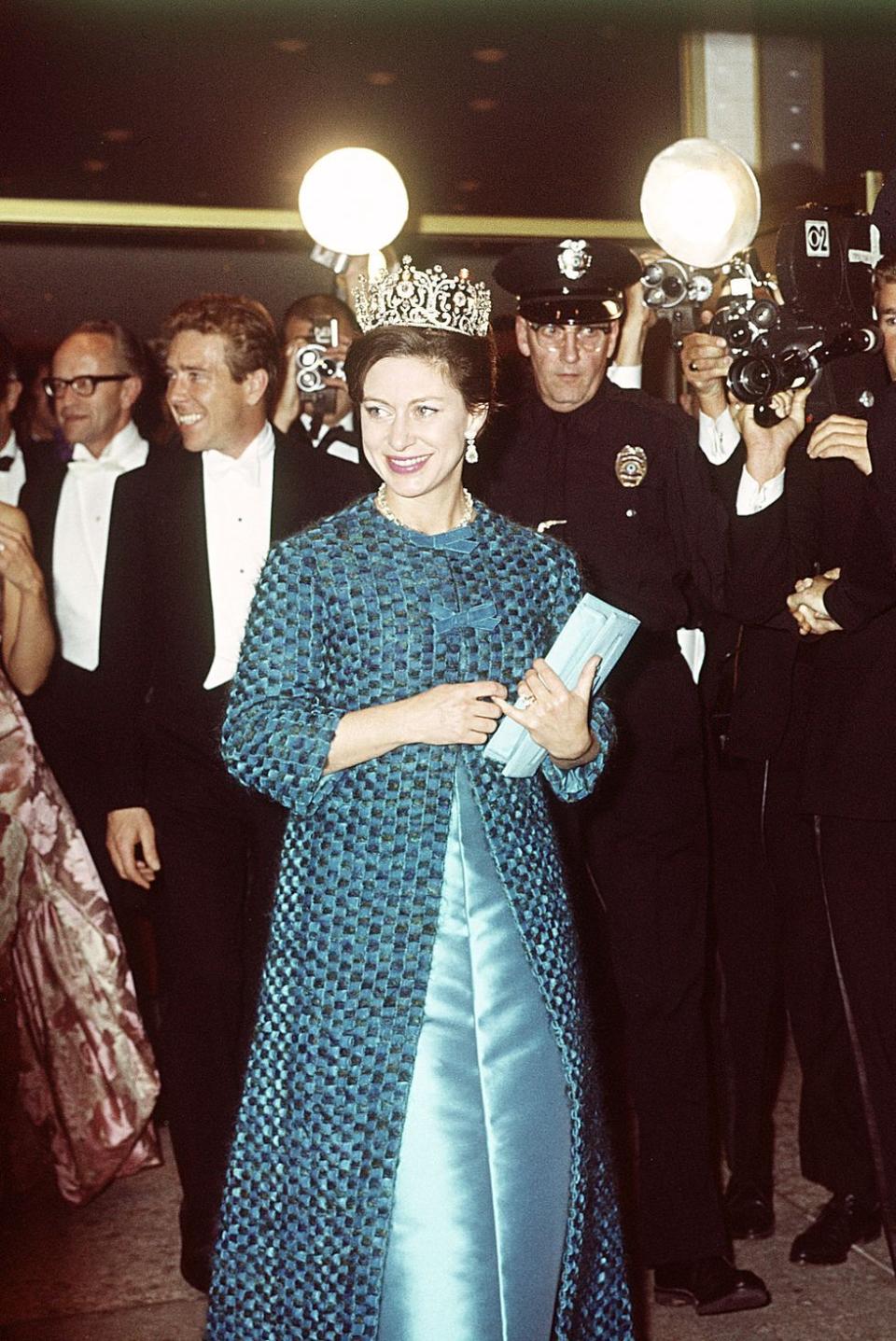 <p>Princess Margaret followed by Lord Snowdon leaving the Hollywood Palladium in Los Angeles during their visit to America in 1965. The Princess wears a blue dress and coat, topped with a stunning tiara.</p>
