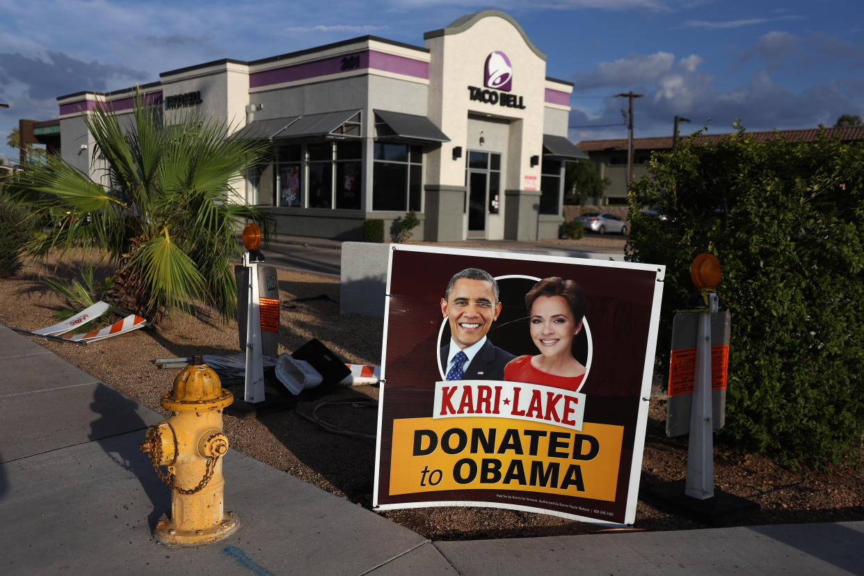 A poster with pictures of Lake and Barack Obama reads: Kari Lake donated to Obama.