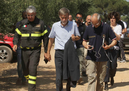 Italian State Secretary to the Prime Minister Graziano Delrio (C) arrives at the site where two passenger trains collided in the middle of an olive grove in the southern village of Corato, near Bari, Italy July 12, 2016. REUTERS/Stringer