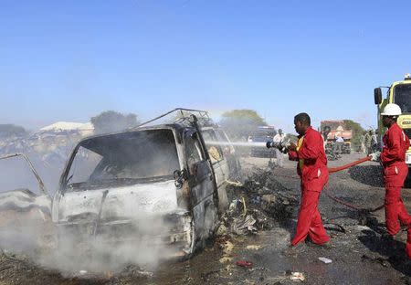 Firemen extinguish fire from the wreckage of a van after a suicide car bomb explosion targeting peacekeeping troops in a convoy outside the capital Mogadishu September 8, 2014. REUTERS/Feisal Omar