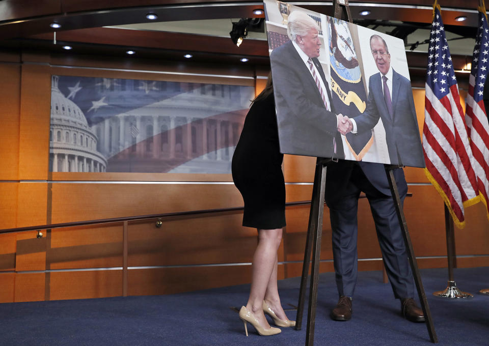 <p>An aide, left, speaks with Rep. Joe Crowley, D-N.Y., chairman of the House Democratic Caucus, and House Oversight and Government Reform Committee ranking member, on Capitol Hill in Washington, May 17, 2017, behind a photograph of President Donald Trump and Russian Foreign Minister Sergey Lavrov, during a news conference. (Photo: Alex Brandon/AP) </p>