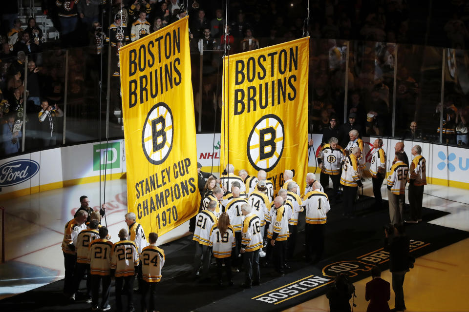 Players on the 1970 and 1972 Stanley Cup-champion Boston Bruins teams raise banners before the Bruins' NHL hockey game against the Montreal Canadiens, as part of the team's season-long centennial celebrations Saturday, Nov. 18, 2023, in Boston. (AP Photo/Michael Dwyer)