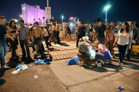 <p>People tend to the wounded outside the Route 91 Harvest Country music festival grounds after an apparent shooting on Oct. 1, 2017 in Las Vegas, Nevada. (Photo: David Becker/Getty Images) </p>