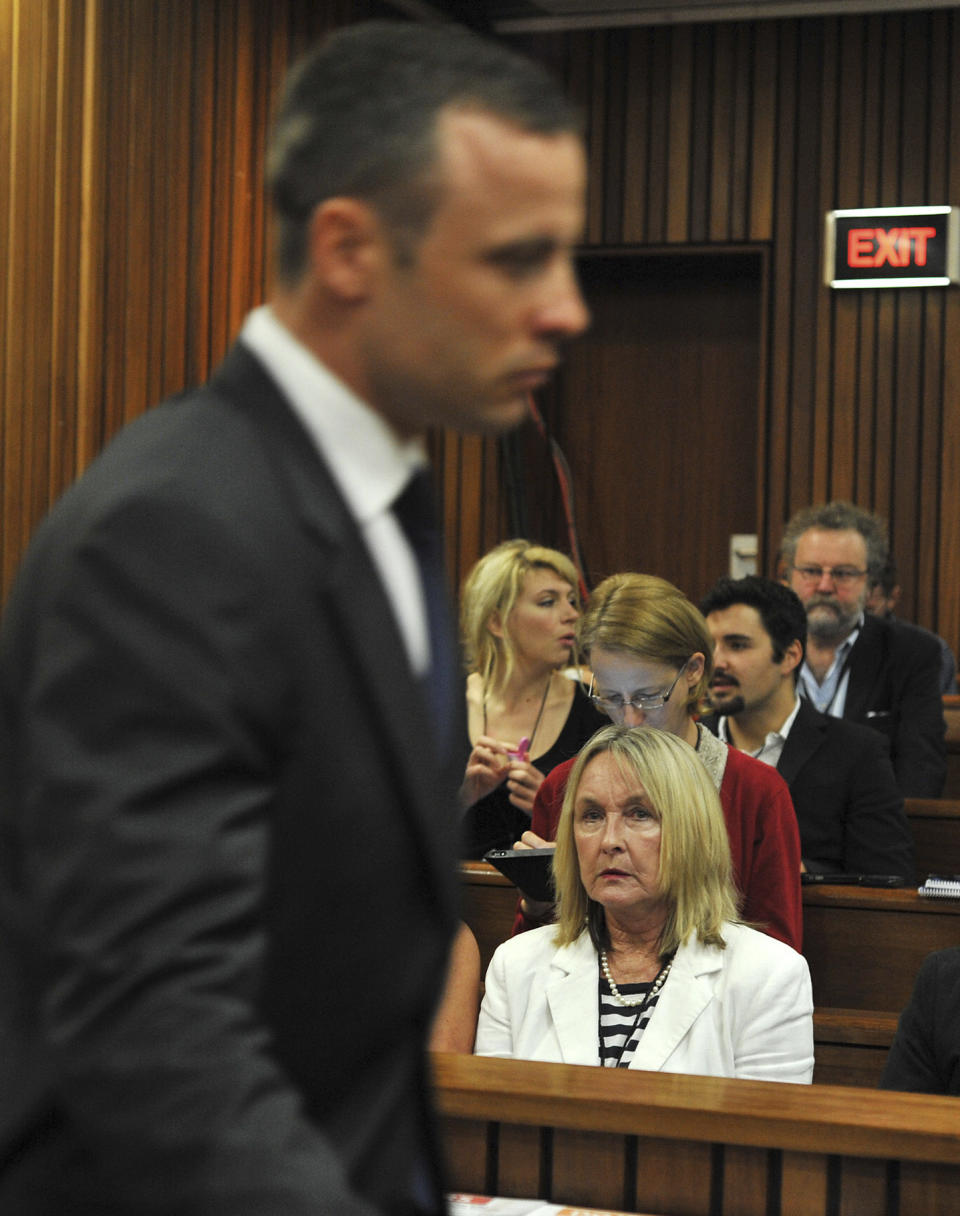 Oscar Pistorius, left, walks past June Steenkamp, right, the mother of the late Reeva Steenkamp, upon his arrival at the high court in Pretoria, South Africa, Monday, March 24, 2014. The trial of Pistorius, who is charged with murder for the shooting death of his girlfriend Reeva Steenkamp on Valentines Day in 2013, is beginning its fourth week. The prosecution has said it will wrap up its case against the double-amputee runner this week after calling four or five more witnesses, beginning Monday. (AP Photo/Ihsaan Haffejee, Pool)