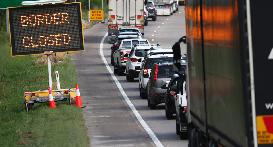 Photo shows a huge queue of cars and a 'border closed' sign.