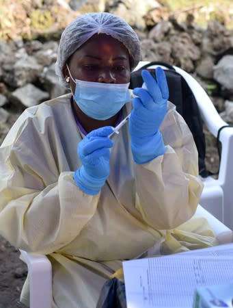 A Congolese health worker prepares to administer an ebola vaccine to a man at the Himbi Health Centre in Goma