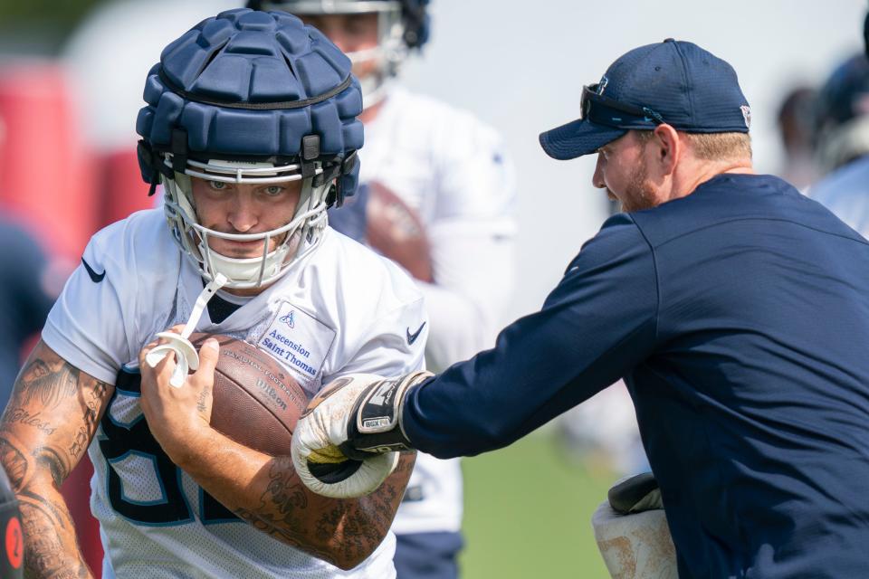 Tennessee Titans tight end Briley Moore (82) holds on to the ball as tight ends coach Luke Steckel tries to punch it out during a training camp practice at Ascension Saint Thomas Sports Park Sunday, Aug. 14, 2022, in Nashville, Tenn. 