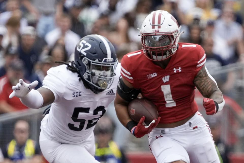 Wisconsin's Chez Mellusi runs past Georgia Southern's Jacob Ferguson (52) during the first half of an NCAA college football game Saturday, Sept. 16, 2023, in Madison, Wis. (AP Photo/Morry Gash)