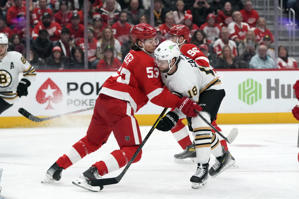 Detroit Red Wings defenseman Moritz Seider (53) defends Boston Bruins center Pavel Zacha (18) during the first period of an NHL hockey game, Sunday, Dec. 31, 2023, in Detroit. (AP Photo/Carlos Osorio)